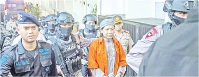  ??  ?? POLIS mengiringi Abdurrahma­n ke mahkamah untuk mendengar cadangan pendakwa raya di Jakarta semalam. — Gambar AFP