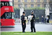  ?? ?? Officers collect floral tributes for Sir David Amess laid in Parliament Square yesterday. The Met has worked with Parliament on security for MPs
