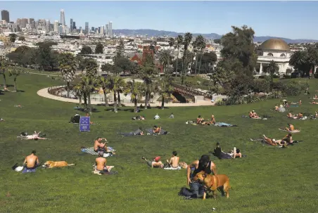  ?? Liz Hafalia / The Chronicle ?? Sunbathers at Dolores Park on April 14. The park can reopen, but with social distancing practiced.