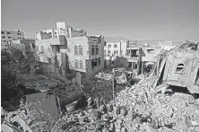  ?? Hani Mohammed / Associated Press ?? People inspect the wreckage of buildings hit by Saudi-led coalition airstrikes in Sanaa, Yemen, on Tuesday, a day after a Houthi-claimed attack on an oil facility in the UAE.