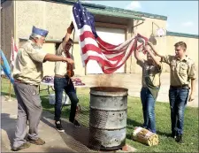  ?? Janelle Jessen/Herald-Leader ?? Less Carroll, of American Legion Post 29, directed members of Boy Scout Troop 3766 as they retired U.S. flags during a ceremony on Saturday evening.