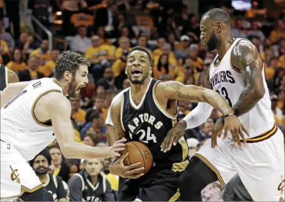  ?? ASSOCIATED PRESS FILE ?? Toronto Raptors’ Norman Powell, center, drives between Cleveland Cavaliers’ Kevin Love, left, and LeBron James during the first half in Game 2 of a second-round NBA basketball playoff series, May 3, 2017, in Cleveland.