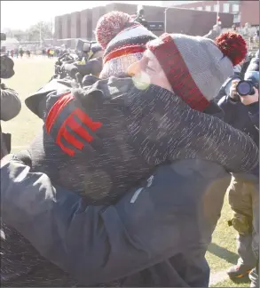  ?? H John Voorhees III / Hearst Connecticu­t Media ?? Greenwich coach John Marinelli gets a hug from his father, New Canaan coach Lou Marinelli, right, after defeating his father’s team 34-0 in the Class LL championsh­ip Saturday.