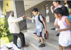  ?? Carol Kaliff / Hearst Connecticu­t Media ?? Dr. Jamel Gibson, principal of Shelter Rock School, sees kids off as they head out the door Monday. Danbury public schools had an early dismissal Monday because of the heat.