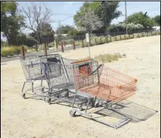  ?? VALLEY PRESS FILES ?? Three abandoned shopping carts, including one from WinCo Foods and one from Home Depot, sit in a vacant lot off Sierra Highway in July 2018. The Lancaster City Council will consider adoption of a resolution to establish fees for the retrieval and daily storage of shopping carts located off of the cart owner’s premises.