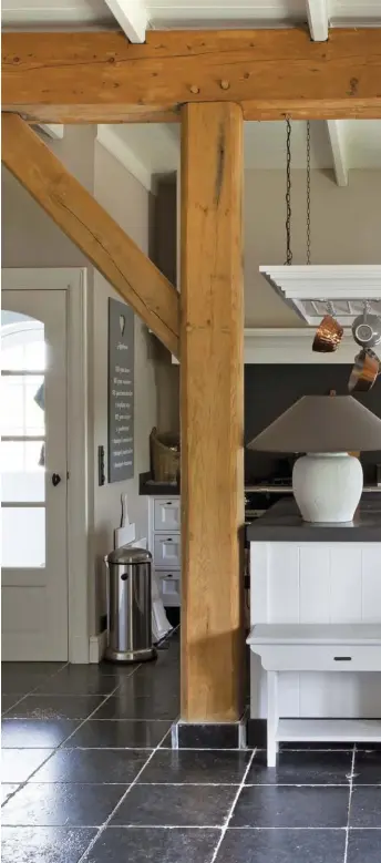  ??  ?? HISTORY REBORN.
The couple kept the pine beams from the old barn exposed as a reminder of the space’s original use as a cow stable. The new kitchen island tucks neatly beside one.