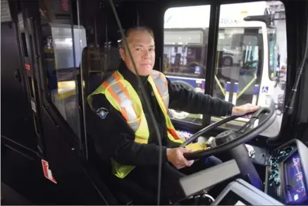  ?? DAVID BEBEE, RECORD STAFF ?? Grand River Transit driver Darren Mahon sits at the wheel of a city bus outfitted with a driver shield.