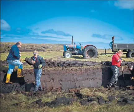  ??  ?? FUEL: Dan Smith, Angus Smith, Callum Mckenzie and Alastair Maclean extract peat from a moor near the village of Cross in Lewis,