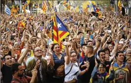  ?? EMILIO MORENATTI / ASSOCIATED PRESS ?? Catalans cheer Friday in Barcelona, Spain, outside the Catalan Parliament after it passed a motion to establish an independen­t Catalan republic. In Madrid, Spain’s Prime Minister Mariano Rajoy said he was firing the Catalan government and the chief of...