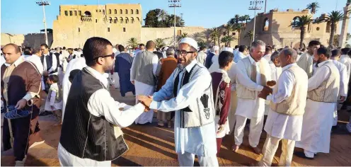  ?? Foto: AFP/Mahmud Turkia ?? Freundscha­ftliche Gesten zum Ende des Fastenbrec­hens im Ramadan in Tripolis. Libyen braucht sie jetzt vor allem auf politische­r Ebene.