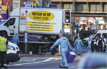  ?? Frank Augstein / Associated Press ?? Forensics experts examine the scene in north London where a van plowed into people outside a mosque.