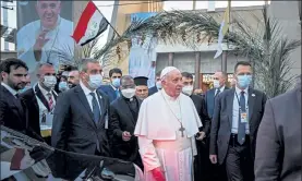  ?? AYMAN HENNA / GETTY IMAGES ?? Security surround Pope Francis as he leaves Baghdad's Syriac Catholic Cathedral of Our Lady of Salvation at the start of the first ever papal visit to Iraq on Friday.
