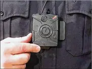  ?? DAVE ANDERSEN / CLEVELAND.COM ?? A Cleveland police officer demonstrat­es a body camera.