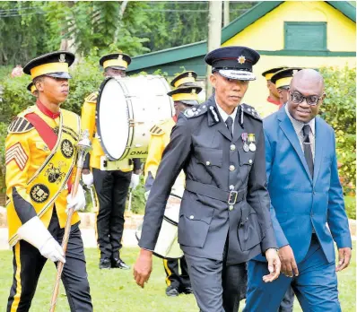  ?? ?? Prospect College’s Principal Gregory Wint (right) and Commission­er of the Jamaica Fire Brigade Stewart Beckford (centre) inspecting the marching band at the Prospect College 2023 graduation ceremony. Drum Major Michael Rowe (left) escort the pair.