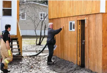  ?? PHOTO PIERRE-PAUL BIRON ?? Michel Roy, qui demeure sur la rue Marcel-roussel dans le secteur Saint-étienne, à Lévis, explique aux pompiers jusqu’à quelle hauteur montait l’eau qui encerclait sa maison.