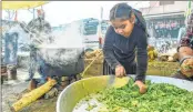  ??  ?? A girl helps farmers to prepare food for fellow farmers during their ongoing protest against new farm laws, at Singhu Border.