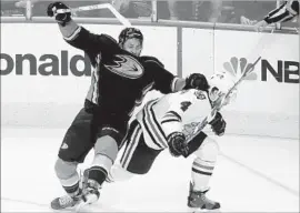  ?? Luis Sinco Los Angeles Times ?? EMERSON ETEM, left, clashes with Chicago’s Niklas Hjalmarrso­n during the 2015 Western Conference finals in Anaheim. Etem is glad to return to the Ducks.