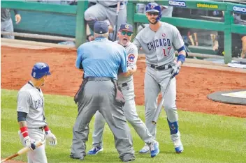  ?? AP PHOTO/GENE J. PUSKAR ?? Chicago Cubs manager Joe Maddon, center, yells toward Pittsburgh’s dugout as he is restrained by home plate umpire Joe West and Cubs right fielder Kris Bryant during the fourth inning of a game against the host Pirates on July 4. Maddon was ejected.