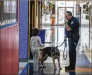  ?? RICARDO B. BRAZZIELL / AMERICAN-STATESMAN ?? Pflugervil­le police officer Jefferson Schaefer and his K-9 partner, Cora, make a routine walk through Rowe Lane Elementary School in Pflugervil­le in 2016. Schaefer, no longer with the department, claims he is owed compensati­on for Cora’s care.