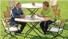  ?? Fotos: TASS, Imago, afp ?? Unterkühlt: Putin beim Meinungsau­stausch mit Bundeskanz­lerin Angela Merkel im Park von Schloss Meseberg.