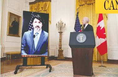  ?? SAUL LOEB / AFP VIA GETTY IMAGES ?? U.S. President Joe Biden stands next to a large monitor showing Prime Minister Justin Trudeau at a White House press conference Tuesday, after the two leaders held a virtual bilateral meeting — the first for the new president.