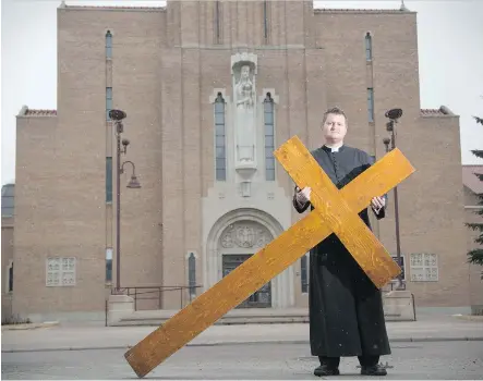  ?? FOR THE CALGARY HERALD ?? Deacon Adrian Martens with the Roman Catholic Dioceses of Calgary holds the cross used during Good Friday’s celebratio­n.