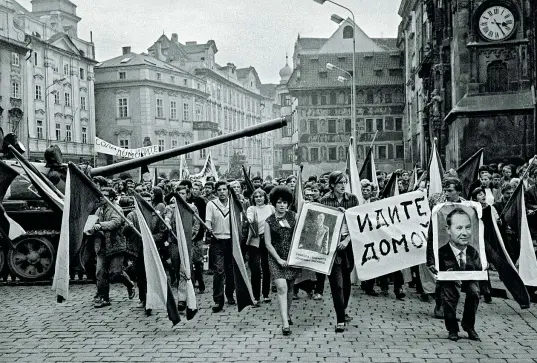  ??  ?? Carro armato
Un tank dell’armata Rossa staziona nel centro di Praga, durante l’invasione dell’agosto 1968, circondato dai cittadini della capitale dell’allora Cecoslovac­chia che sfilano per protesta. In un cartello, scritto in russo, compare l’invito...