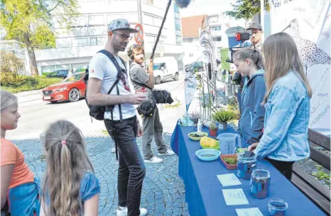  ?? FOTOS: FRANZ LIESCH ?? Eine Reihe Quiz-Aufgaben und Ausstellun­gsstücke hat die Nabu-Kindergrup­pe Laupheim zum Thema Moor auf dem Wochenmark­t für die Passanten vorbereite­t.