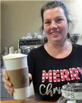  ??  ?? ■ Barista Melissa Smith is handing out a popular cappuccino coffee with cream she has made at her newly opened barista bar in downtown Atlanta.
