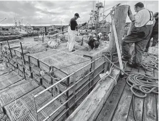  ?? TINA COMEAU • SALTWIRE NETWORK ?? Lobster traps and other gear were loaded onto boats in southweste­rn Nova Scotia on Saturday. Forecasted winds, however, mean the season in Lobster Fishing Area 34 won't start as scheduled Monday.