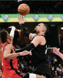  ?? Brandon Dill/Associated Press ?? Grizzlies forward Dillon Brooks, one of five Memphis players to make at least two 3-pointers, puts up a shot over Rockets forward Jabari Smith Jr. on Friday.