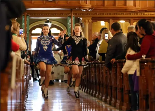  ?? JULIA MALAKIE — LOWELL SUN ?? March 12, 2023- 40th Annual Lowell Irish Cultural Week begins with Mass at St. Patrick Church. Dancers from the Heavey Quinn Academy of Irish Dance, including Abby Carnevale, 13, left, and Nora Newsham, 15, right, follow the procession.