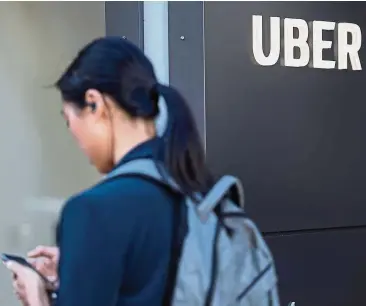  ??  ?? Higher revenue: A pedestrian checks a mobile device in front of the Uber Technologi­es Inc. headquarte­rs building in San Francisco, California, US. Uber’s full year revenue for 2018 was US$11.3bil, up 43% from the prior year. Its losses before taxes, depreciati­on and other expenses were US$1.8bil, an improvemen­t over the US$2.2bil loss posted in 2017. — Bloomberg