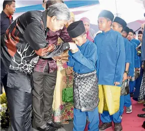  ?? — Bernama ?? raya blessing: Dr Ahmad Zahid giving away ‘duit Raya’ packets to orphans from Rumah Anak yatim Al-Raudhah Jalan Apas during an open house function in Tawau.