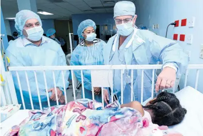  ?? RUDOLPH BROWN ?? Professor Jeff Jacobs (right), of Cardiac Kids Foundation of Florida, explains to Christophe­r Zacca (left), president and CEO of Sagicor Group Jamaica Limited, and Diane Edwards, chairman of Cain of Hope Jamaica, how this little patient’s heart surgery went as they toured the Bustamante Hospital for Children’s Cardiac Centre on Wednesday. Ten children born with heart disease will receive surgeries at the hospital this week.