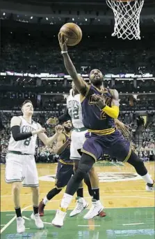  ?? Charles Krupa/Associated Press ?? Cleveland guard Kyrie Irving drives to the basket on Boston forward Jonas Jerebko, left, and center Al Horford.