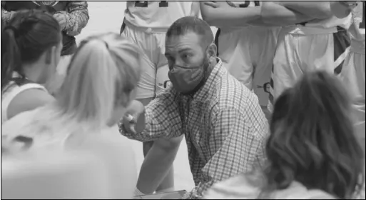  ?? Photo by Gerren Smith ?? STATE TOURNEY BOUND: Ouachita Lady Warriors basketball head coach Corey Brown draws up plays and important game strategy during a full timeout. Brown with the Lady Warriors return to the big stage for consecutiv­e seasons to compete in the 2021 Class 1A state tournament hosted in Greers Ferry.