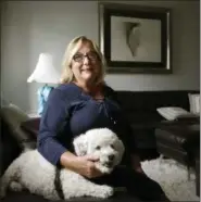  ?? STEVEN SENNE — THE ASSOCIATED PRESS ?? Airbnb operator Jennifer McConnell sits for a photograph with her 10-year-old bichon dog “Skipper,” in a communal area of her home, in Cambridge, Mass. on Sept. 13.