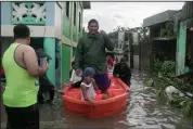  ??  ?? People use a boat for travel Friday after rains from Typhoon Vongfong flooded a village in northeaste­rn Philippine­s. (AP/Melchor Hilotin)