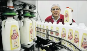  ?? Larry Wong, The Journal, file ?? Jonathan Avis, founder and owner of Saxby Foods Ltd., holds a jug of organic
milk at the company’s organic milk production plant in March 2011.