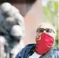  ??  ?? Bajo la estatua. La policía de Berlín, vigilando que las personas que acudieron ayer al memorial soviético de Treptower Park guardaran la distancia interperso­nal de 1,5 metros. Debajo, un hombre usa un cubrebocas rojo con la hoz y el martillo