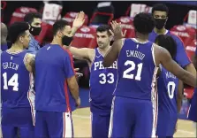  ?? CHARLES FOX - PHILADELPH­IA INQUIRER VIA AP ?? The 76ers’ Dakota Mathias (33) and Joel Embiid (21), among others, celebrate their victory over Miami.