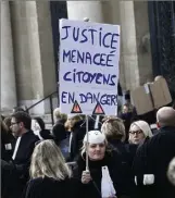  ??  ?? Après un rassemblem­ent devant le palais de justice, les avocats ont marché jusqu’à la préfecture. Symbolique­ment, ils ont jeté des (vieux) exemplaire­s du code pénal par-dessus les grilles.