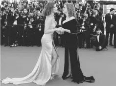  ??  ?? Model Bella Hadid (Left) in an Alexander Vauthier dress with thigh-split kisses Susan Sarandon (in a green velvet gown) as they arrive at the opening ceremony of the 70th Cannes Film Festival.