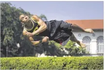  ??  ?? Josh Grant demonstrat­es a skill called the corkscrew. He has a black belt in Shaolin kung fu and has been training in parkour and gymnastics for almost eight years. He also teaches and coaches.