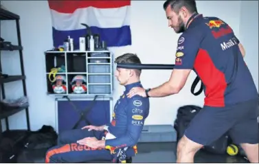  ??  ?? Verstappen realiza ejercicios de calentamie­nto en el cuello antes del GP de Abu Dhabi, el último de 2020.