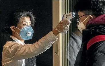  ?? GETTY IMAGES ?? A Starbucks worker checks the temperatur­e of a customer at Beijing Capital Airport. More than 100 cases of coronaviru­s have been confirmed in the city.