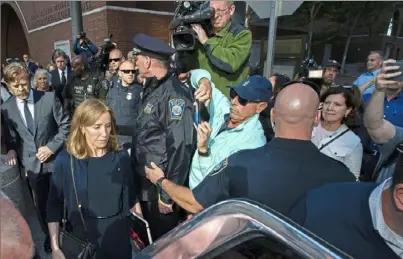  ?? Joseph Prezioso/AFP/Getty Images ?? Actress Felicity Huffman, escorted by husband William H. Macy, left, makes her way out of court Friday in Boston, where she was sentenced to 14 days in jail, a year of probation, a $30,000 fine and 250 hours of community service for her role in a nationwide college admissions scandal.