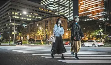  ?? — AFP ?? Coping well: Pedestrian­s in front of the BOJ headquarte­rs in Tokyo. Its unannounce­d currency interventi­on, ramped-up bond buying and extra budget have helped the Japanese economy.