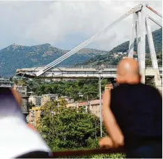  ?? Foto: Gregorio Borgia, dpa ?? Fassungslo­se Blicke auf die eingestürz­te Brücke in Genua. Die Katastroph­e gilt vielen Italienern als Symbol für den Zustand des Landes.